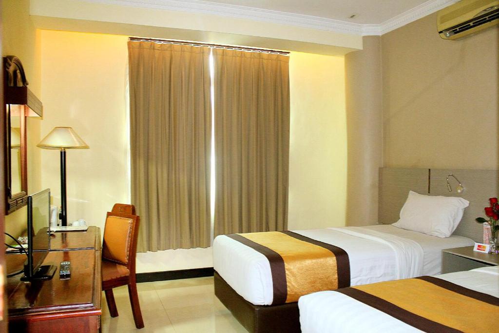 Postel nebo postele na pokoji v ubytování Pandanaran Hotel