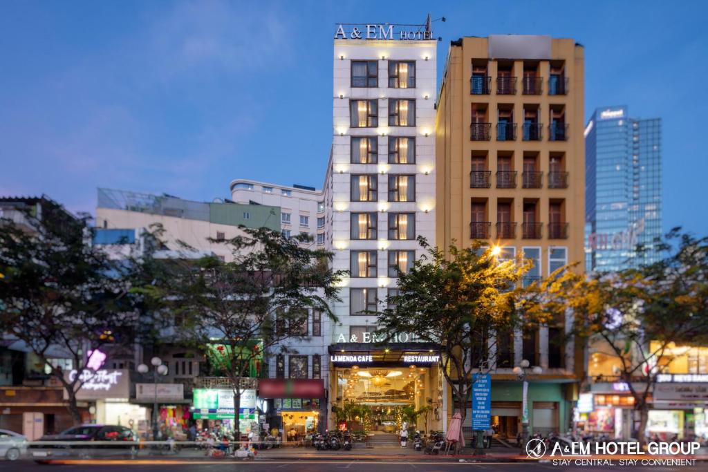 un alto edificio blanco en una ciudad con árboles en A&EM Phan Boi Chau, en Ho Chi Minh