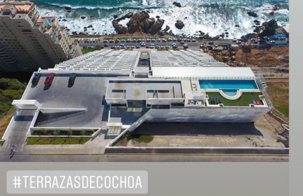 une photo d'un grand bâtiment avec l'océan dans l'établissement Terrazas de Cochoa, à Viña del Mar