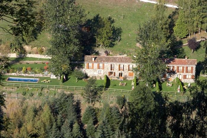 una vista aerea di una grande casa con animali in un campo di Apartamentos Rurales Les Barnedes a Molló