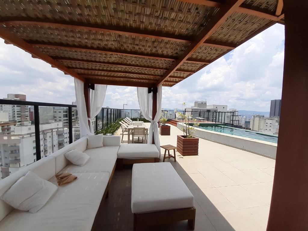 a living room with a white couch on a roof at Roof Top Bela Cintra Residence in Sao Paulo