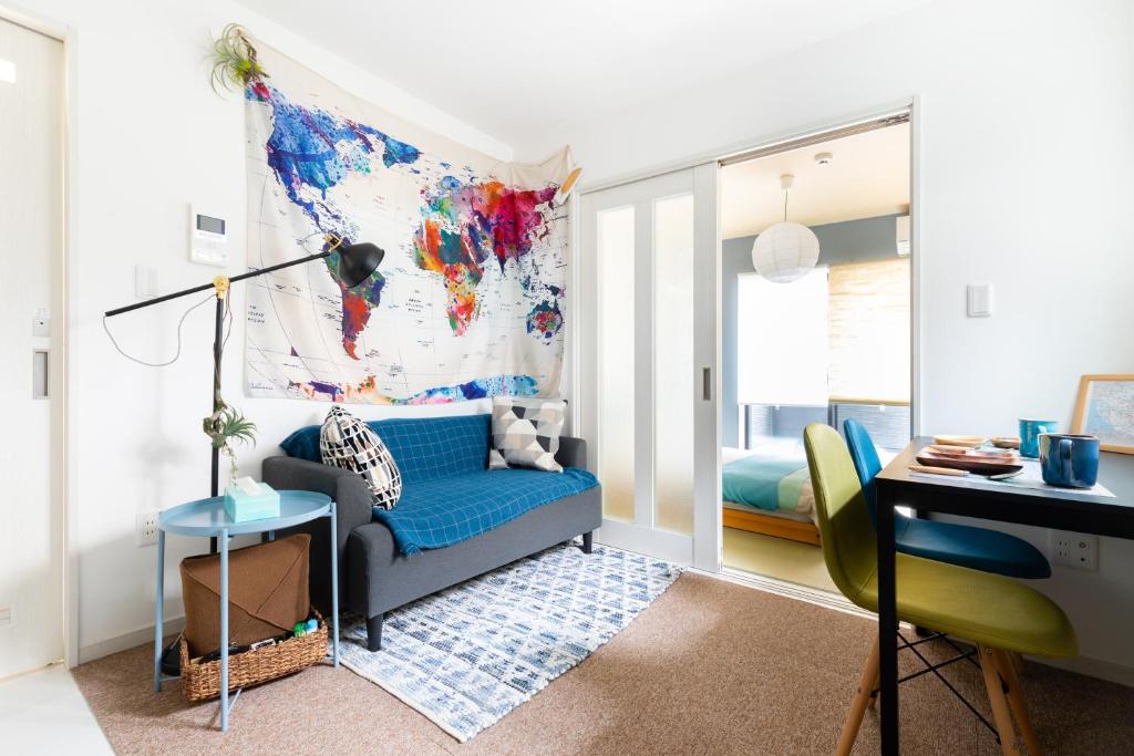 a living room with a blue couch and a desk at Osaka SAYURI Guesthouse - S&S ABENO 101 in Osaka