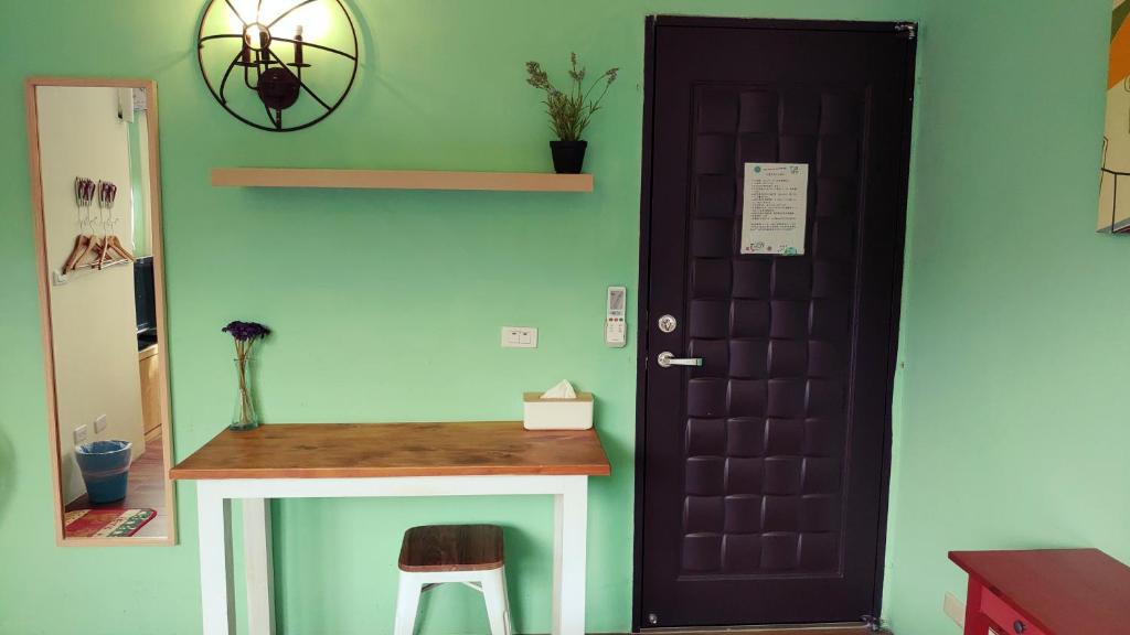 a black door in a room with a table and a stool at Hejia B&amp;B in Hualien City