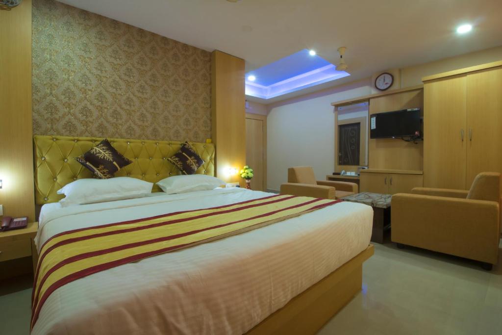 um quarto de hotel com uma cama grande e uma sala de estar em CITY VIEW em Port Blair