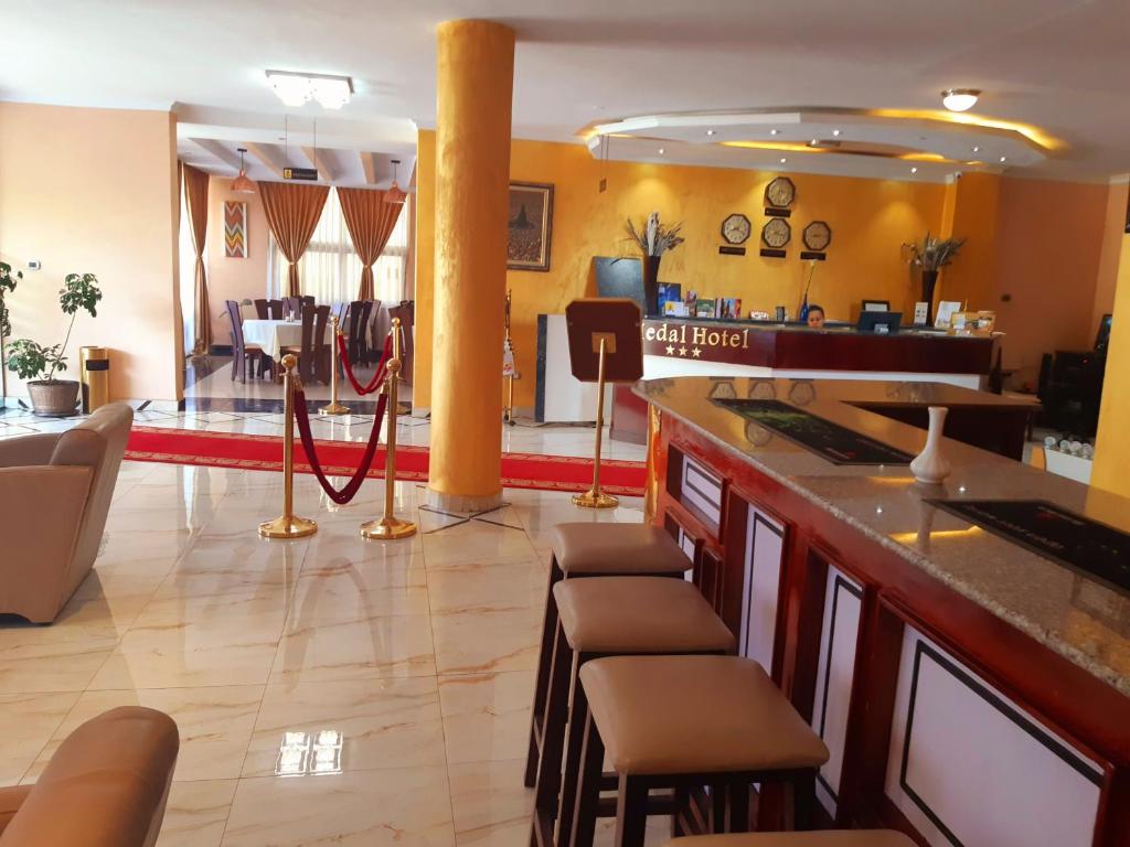 un ristorante con bar con sgabelli e una hall di Medal hotel ad Addis Abeba
