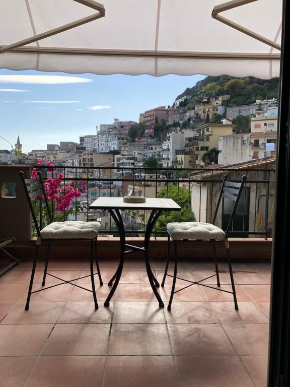 d'une table et de deux chaises sur un balcon avec vue. dans l'établissement Suite Gardenia, à Taormine