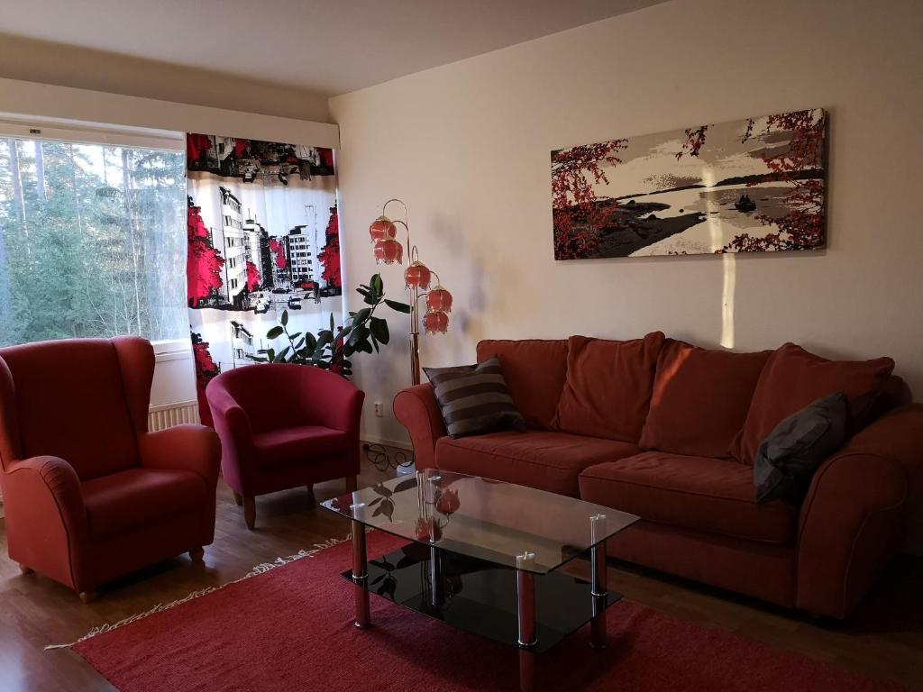 a living room with a couch and two chairs and a table at Nasta Apartment in Nastola