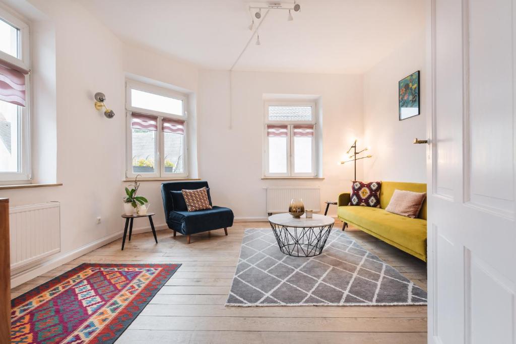 #1 AUGSBURG Altstadtjuwel في اوغسبورغ: غرفة معيشة مع أريكة صفراء وطاولة