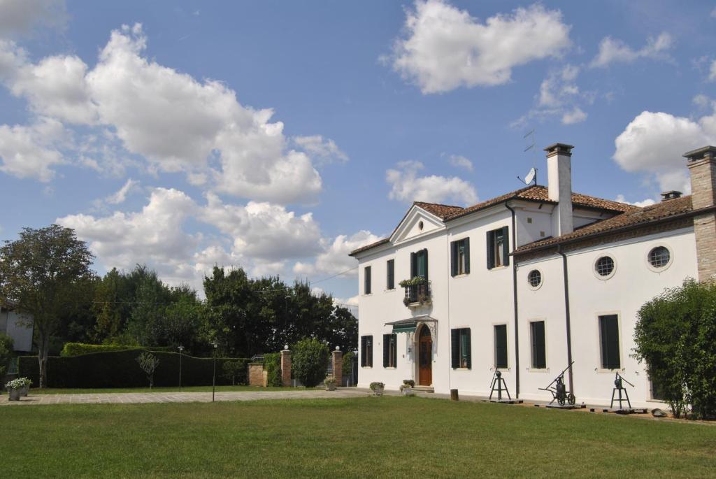 une maison blanche avec des vélos garés devant elle dans l'établissement Agriturismo Villa Greggio, à Casalserugo