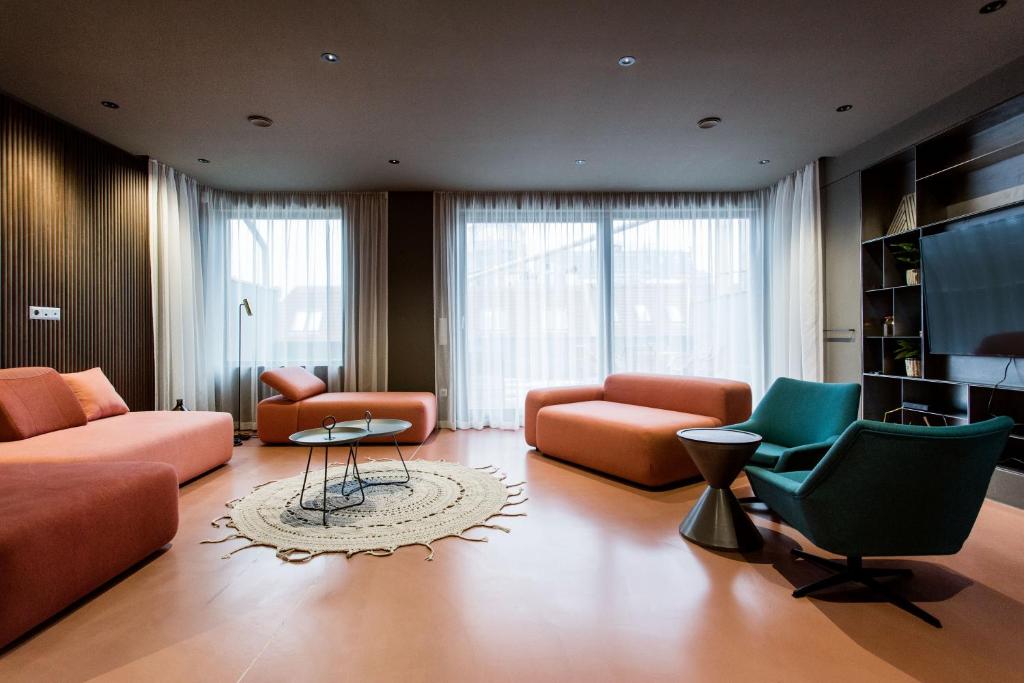een woonkamer met oranje meubels en groene stoelen bij K52 luxury 4BDRM 4BTHRM apartment in Boedapest