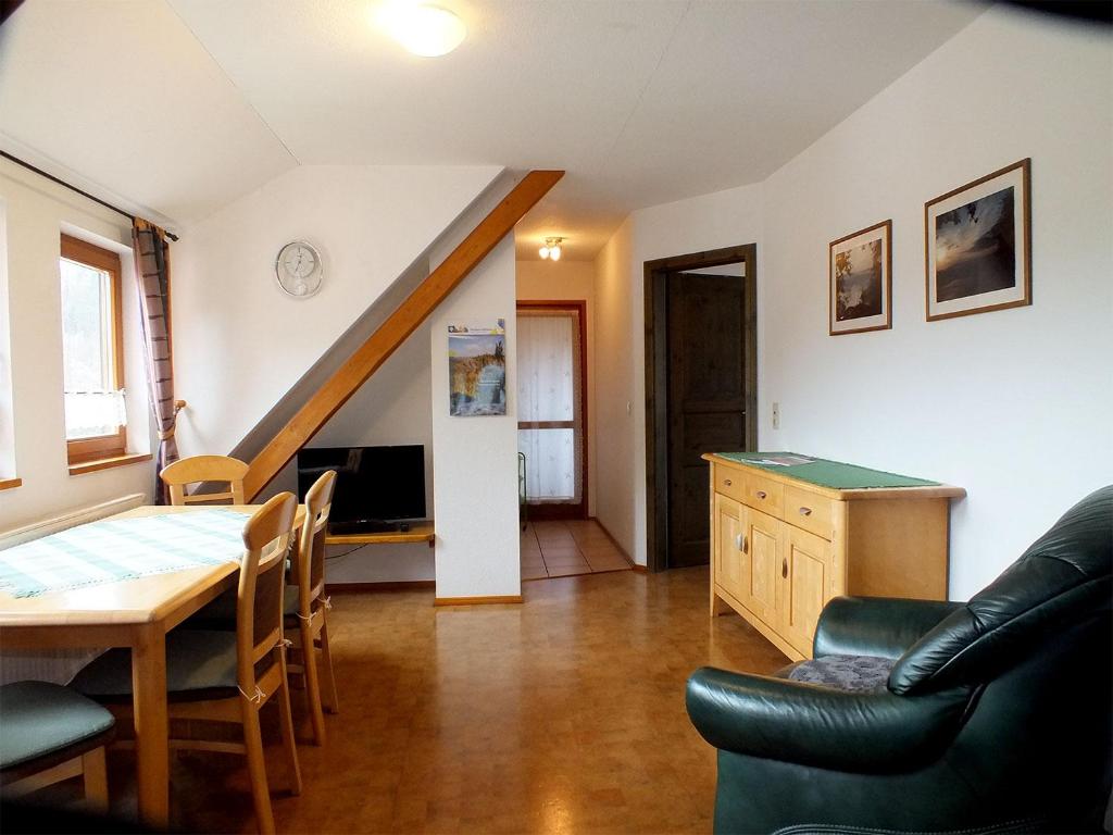 ein Wohnzimmer mit einem Esstisch und einer Treppe in der Unterkunft Gästehaus Schrot in Bad Schandau