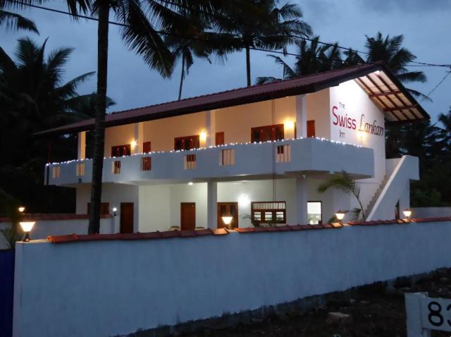 a large white building with a sign on it at The Swiss Lankan in Ahangama