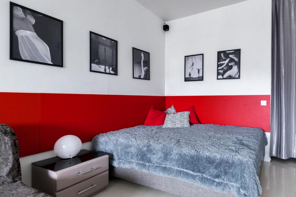 1 dormitorio con paredes rojas y blancas y 1 cama en Rental SPb Studios Varshavskaya, en San Petersburgo