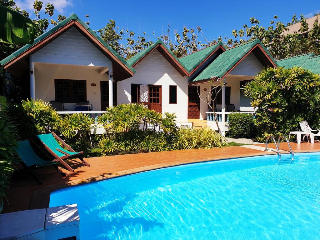 a house with a swimming pool in front of a house at Surin House in Surin Beach