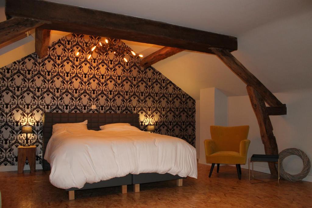 Schlafzimmer mit einem Bett mit einer schwarz-weißen Wand in der Unterkunft Label Semois Gite rural 3 épis in Bouillon