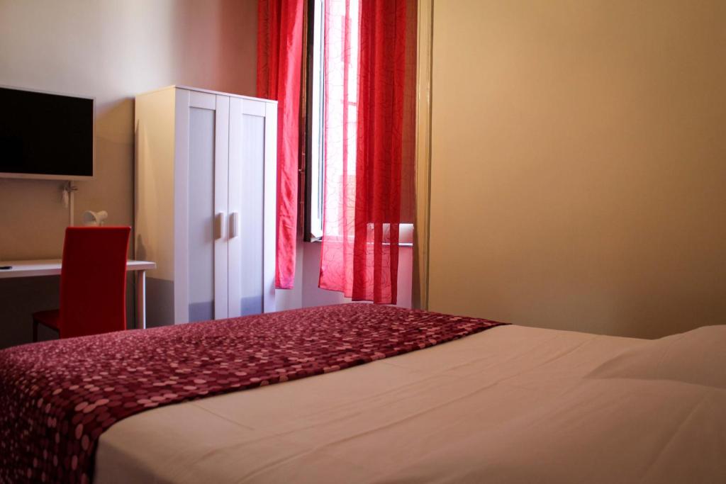 カターニアにあるi 2 puttiniのベッドルーム1室(ベッド1台付)、赤いカーテン付きの窓が備わります。