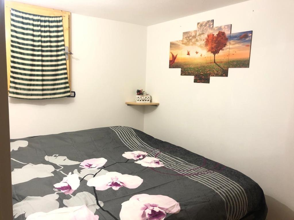een slaapkamer met een bed met roze bloemen erop bij casa della neve in Foppolo