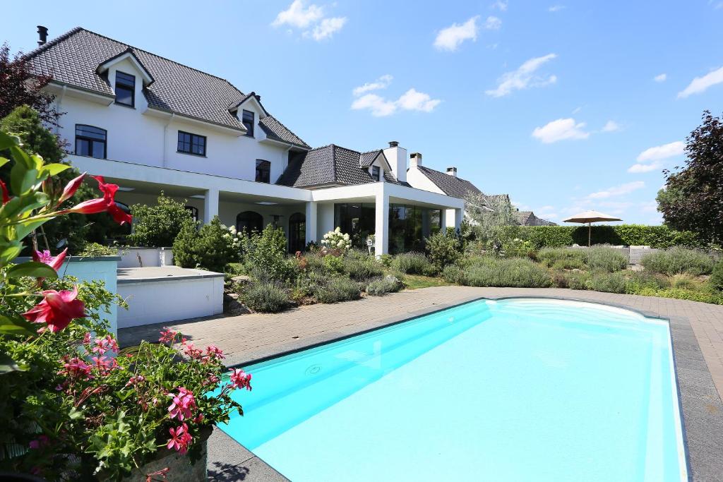 una piscina frente a una casa en A Bascule Bed and Breakfast Maastricht, en Riemst