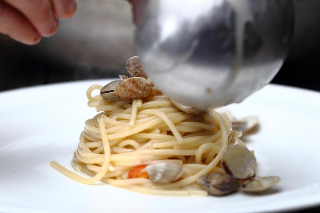 a plate of pasta with mushrooms and nuts on a table at Hotel Du Soleil in Rimini