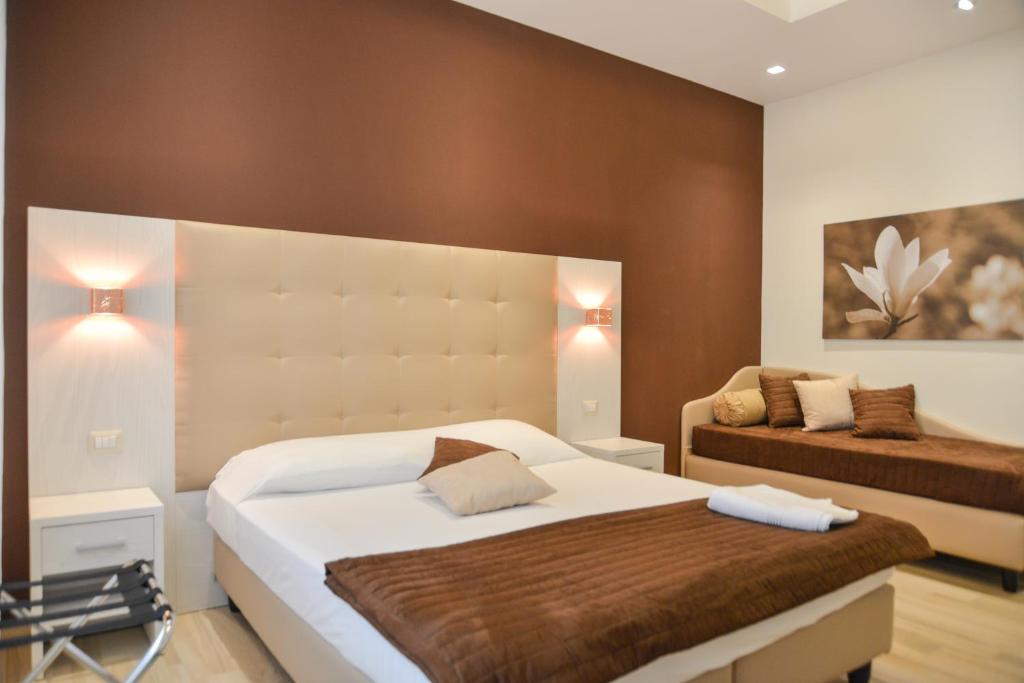 een slaapkamer met een groot bed en een bank bij Your Rhome in Rome