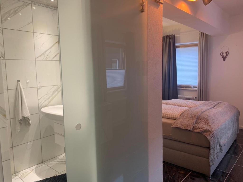 a bedroom with a bed and a bathroom with a shower at Hornhaus in Kitzbühel