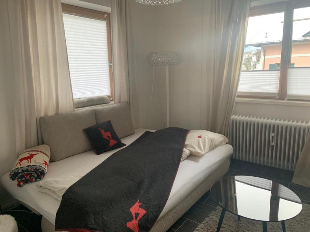 a small bedroom with a bed with a glass table at Hornhaus in Kitzbühel