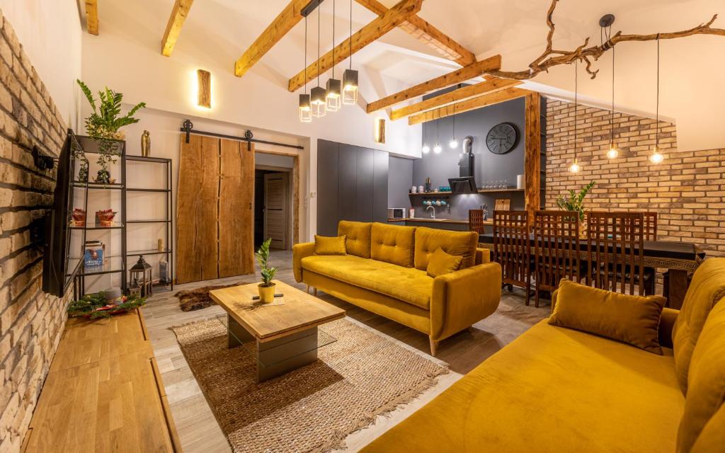 a living room with yellow furniture and a brick wall at PORANEK W GÓRACH in Ustrzyki Dolne