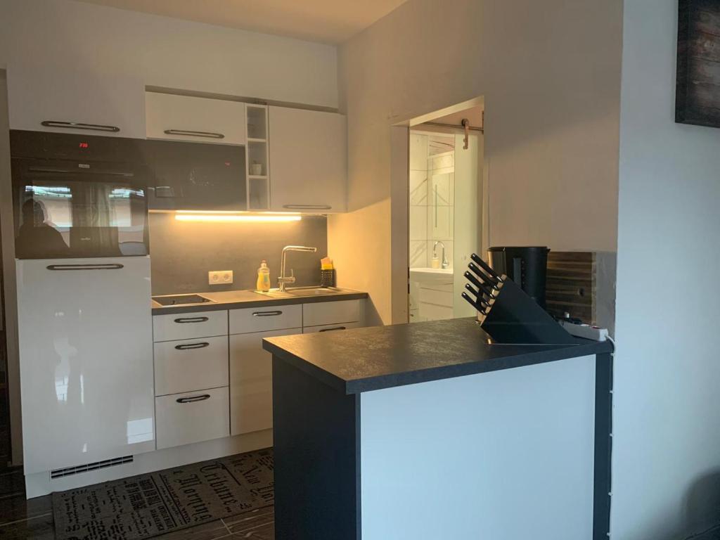a kitchen with white cabinets and a black counter top at Hornhaus in Kitzbühel