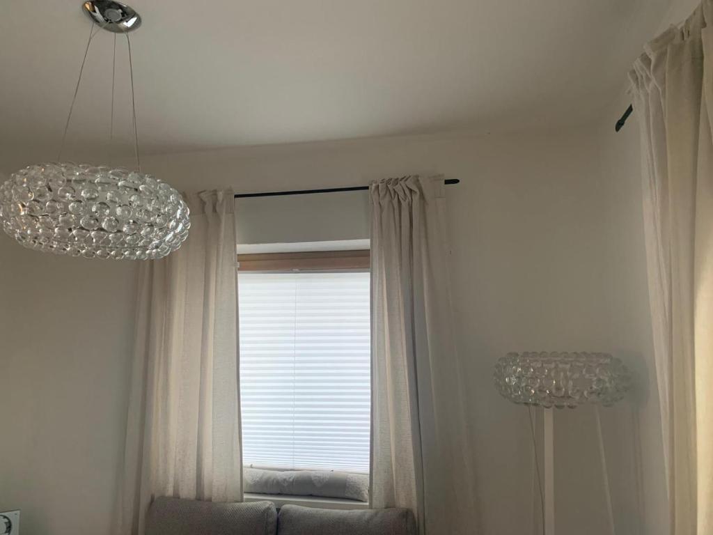 a living room with two chandeliers and a window at Hornhaus in Kitzbühel