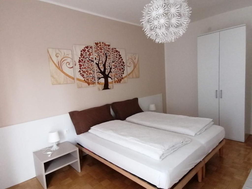 a bed in a room with a tree on the wall at Casa vacanze Sissi in Arco