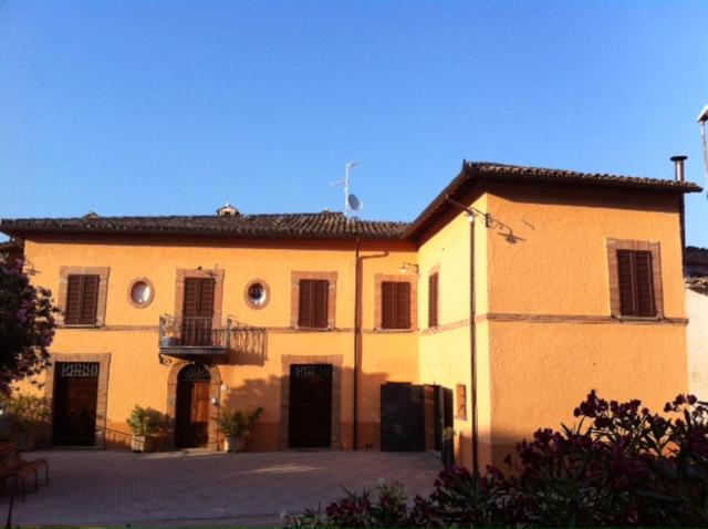 un grande edificio giallo con balcone di B&B Il Casale a Foligno