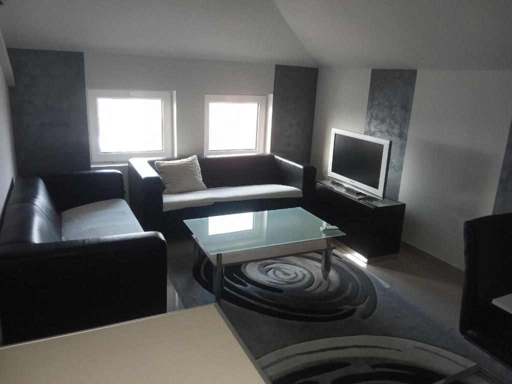 a living room with a couch and a tv at Apartman Djukic in Šabac