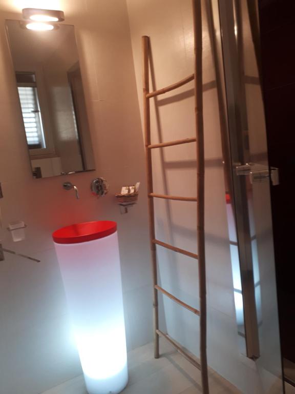 bagno con scala e sgabello rosso di OLYMPUS PARK amnesia a Mesagne