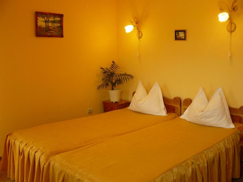 1 dormitorio con 2 camas y paredes amarillas en Cabana Delfinul en Dubova