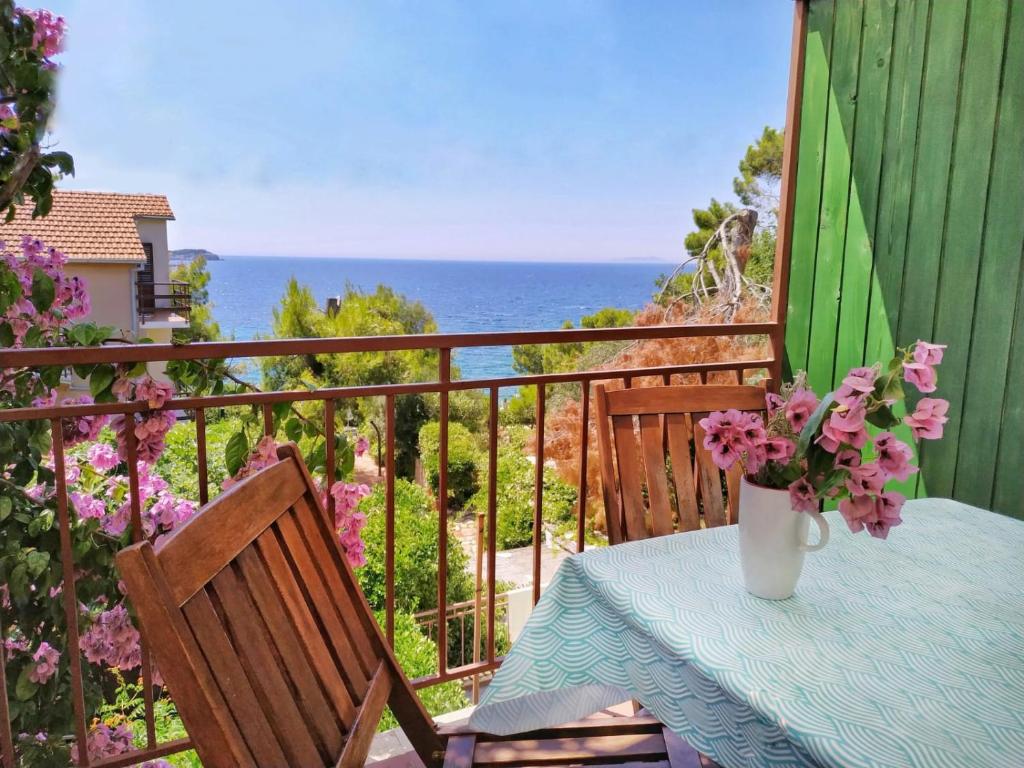 una mesa con un jarrón de flores en el balcón en Apartments Sara Maris, en Prizba