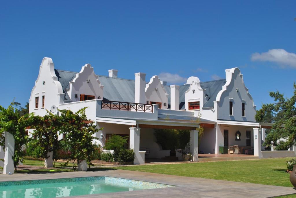 una gran casa blanca con piscina frente a ella en Lombard Villa, en Plettenberg Bay
