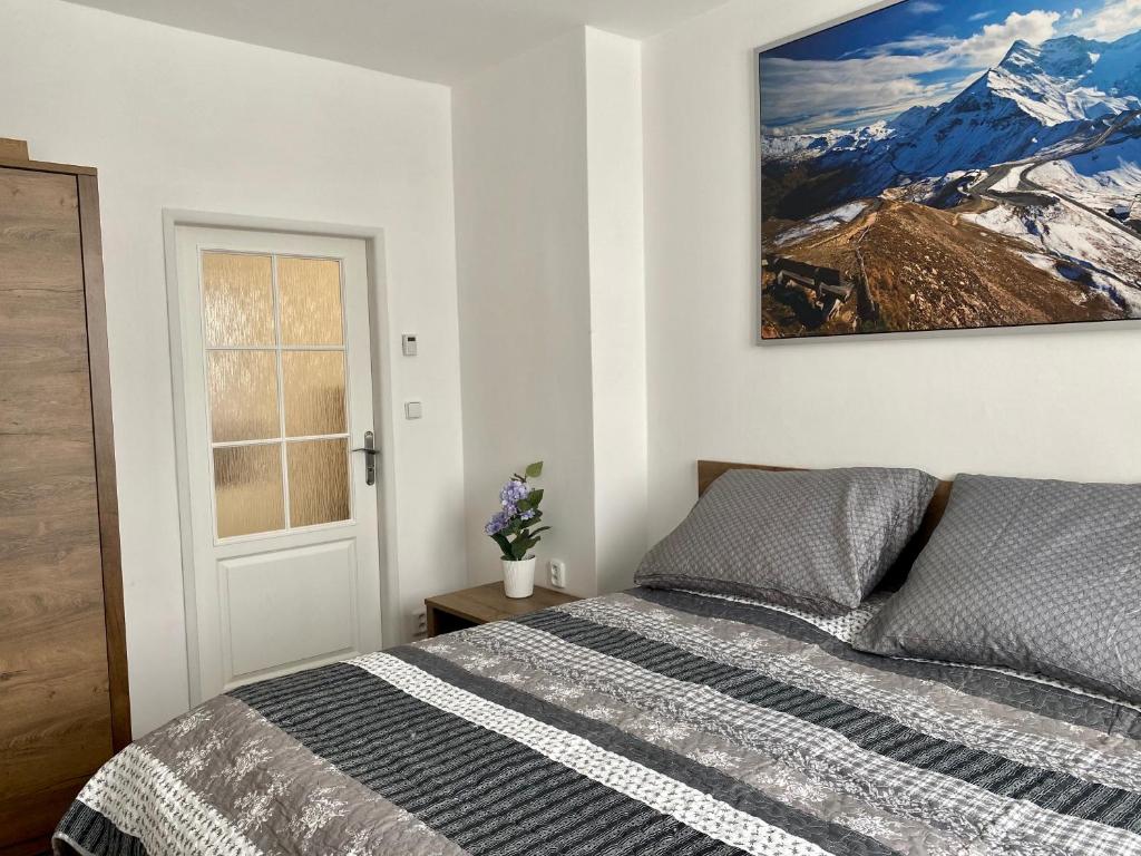 a bedroom with a bed and a picture on the wall at Apartmán Linda in Abertamy