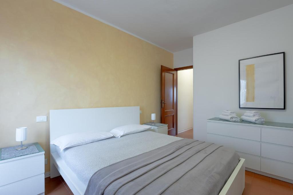 ein weißes Schlafzimmer mit einem Bett und einem Spiegel in der Unterkunft Appartamenti Angelica 21 in Pisa