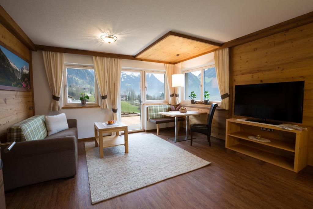 a living room with a couch and a television at Appartement Freiblick in Ramsau im Zillertal
