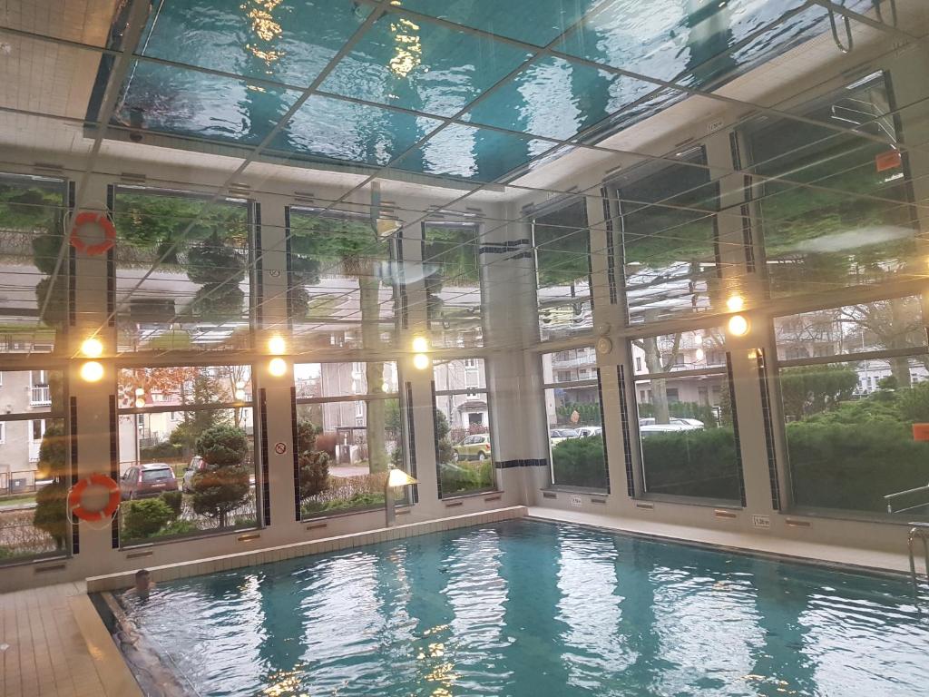 a swimming pool in a building with windows at Apartament w Kołobrzegu in Kołobrzeg