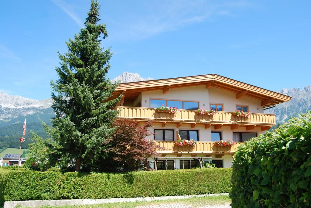 a building with a tree in front of it at Ferienwohnungen Hochfilzer in Ellmau