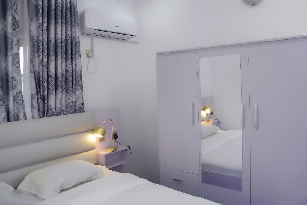 1 dormitorio con 2 camas y espejo en JAYBRITT LUXURY APARTMENT, en Ibadán
