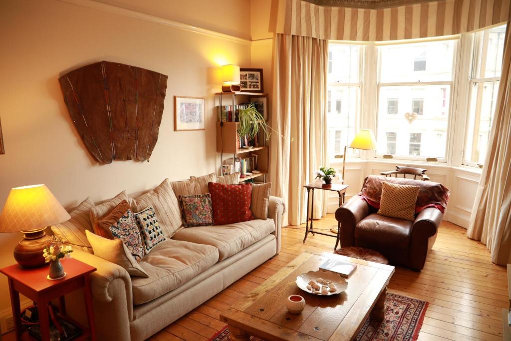 uma sala de estar com um sofá e uma mesa em Woodburn Terrace, Morningside, Edinburgh em Edimburgo