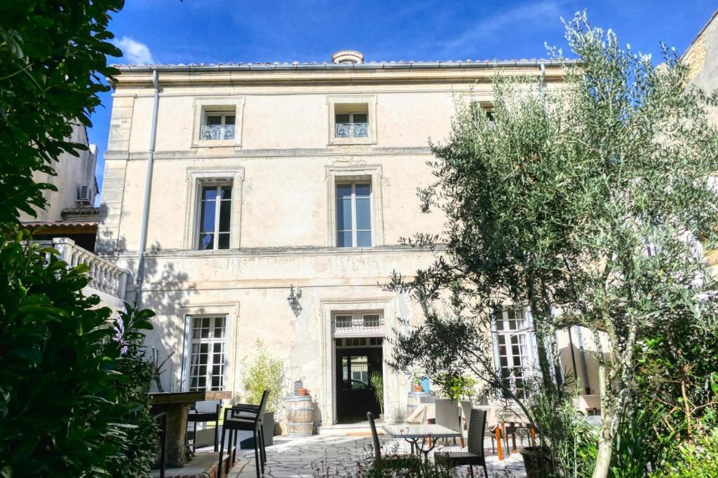 a large white building with a courtyard in front of it at A Propos - Chambres d'Hôtes in Orange