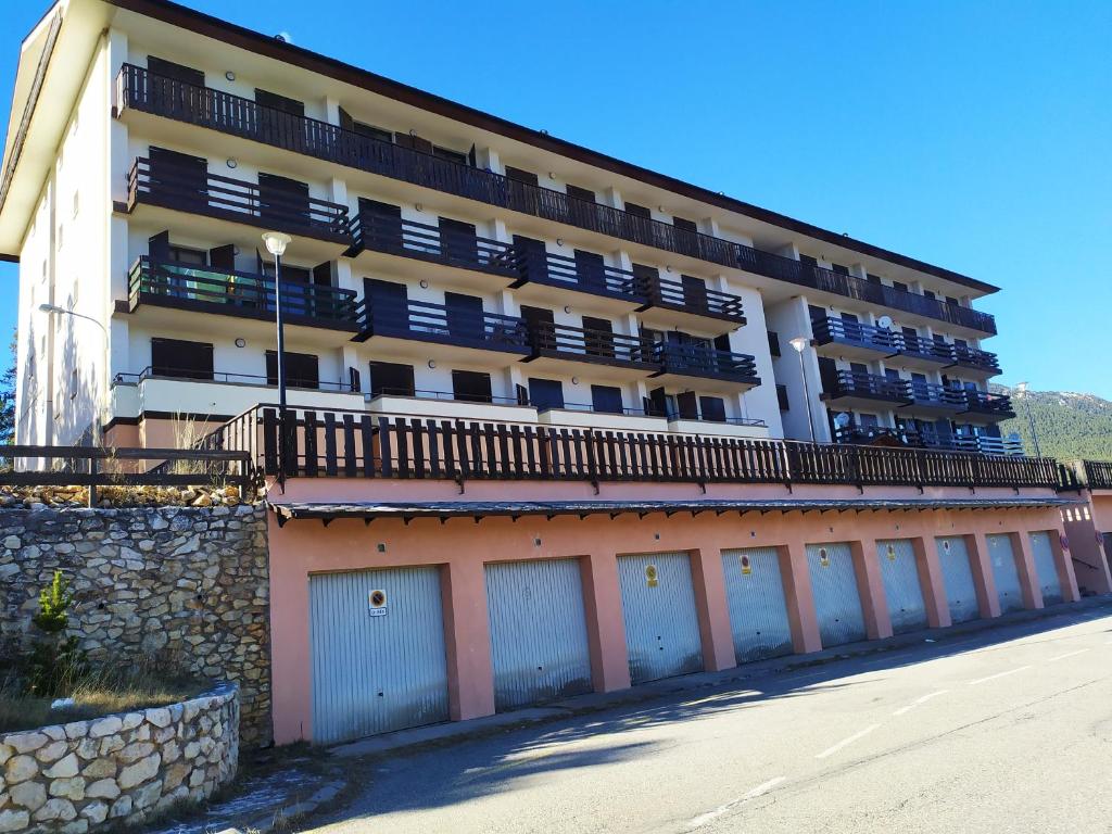 un grand bâtiment avec des garages devant lui dans l'établissement Apartament Donadó - Port del Comte, à La Coma i la Pedra