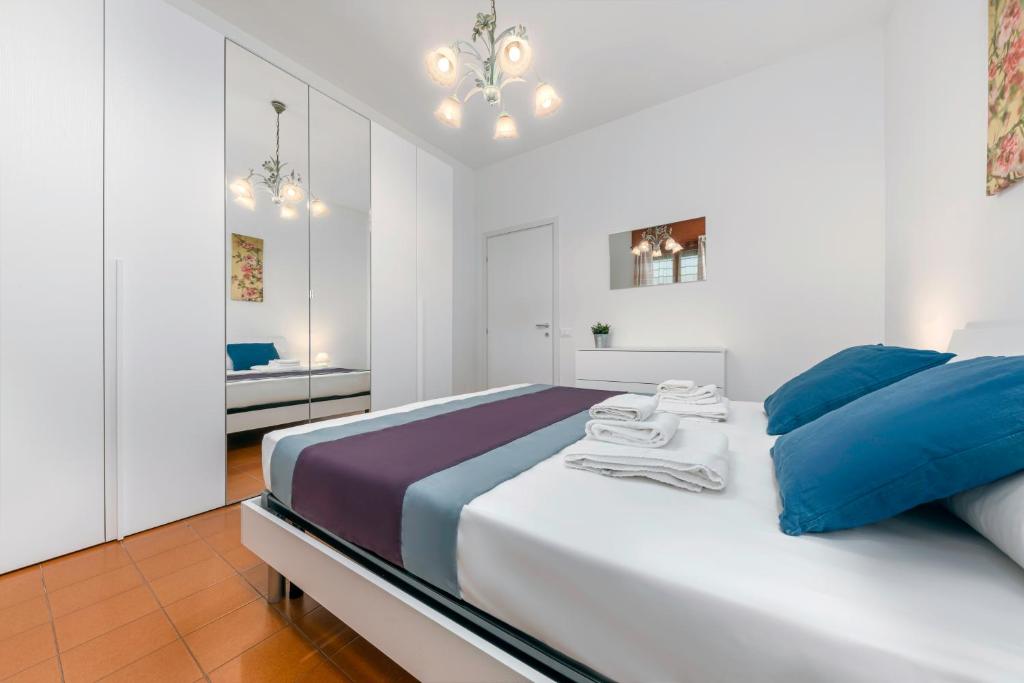 1 dormitorio blanco con 1 cama grande con almohadas azules en Casa da Suite Torre, en Milán