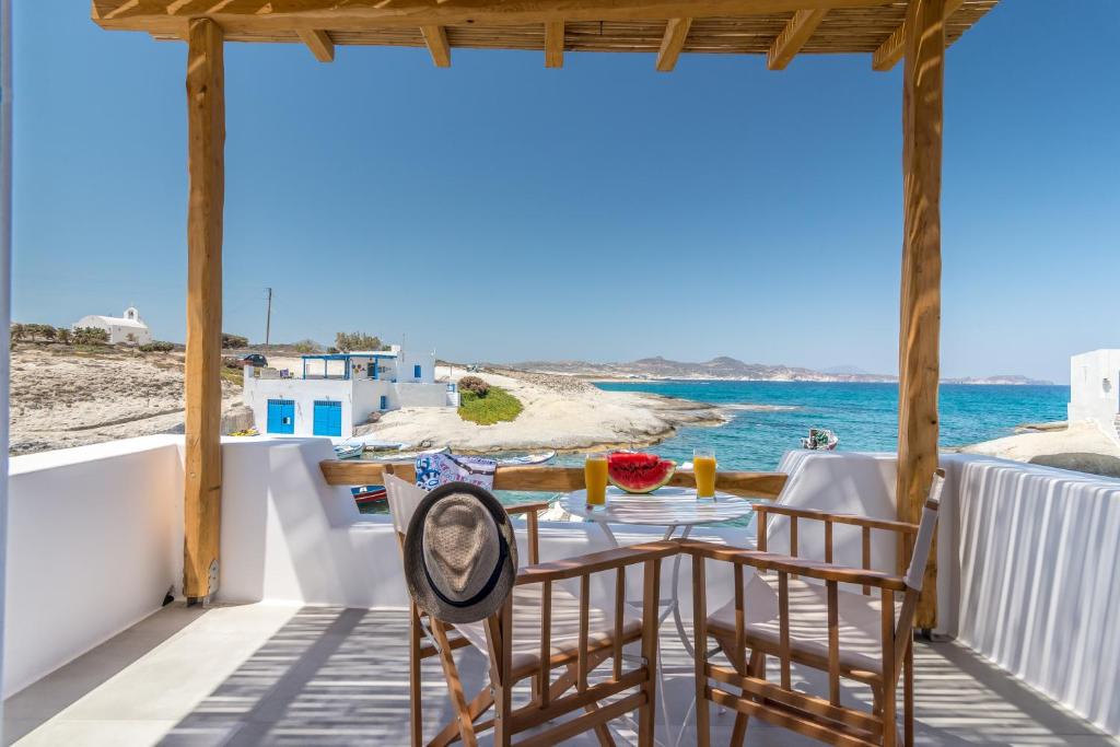 a table and chairs on a balcony overlooking the ocean at Manolis And Filio Home -By The Sea in Pachaina