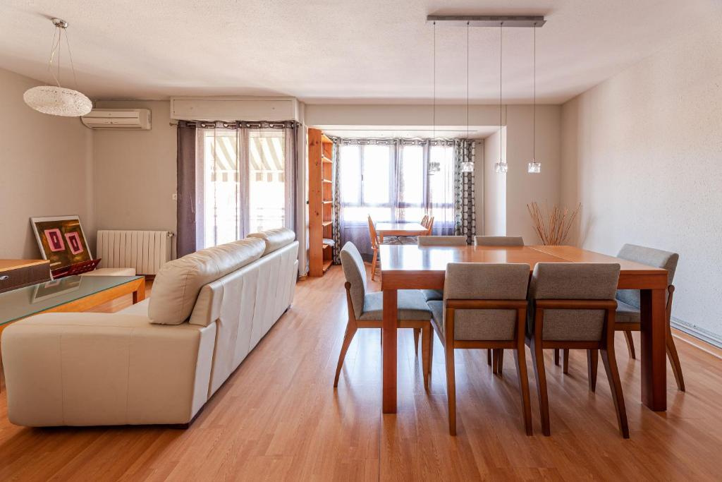 comedor y sala de estar con mesa y sillas en Apartamentos El Llombo, en Ontinyent