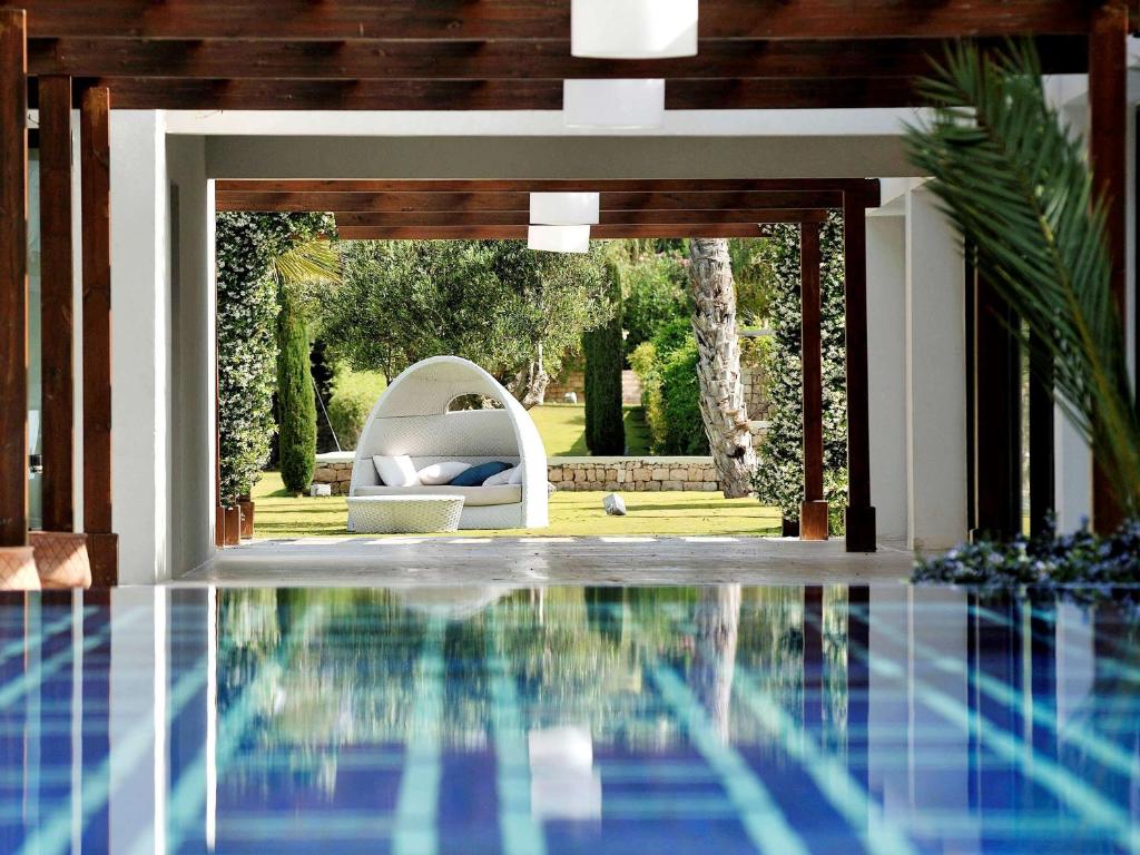 - une piscine avec un canapé et une chaise dans une maison dans l'établissement Sofitel Essaouira Mogador Golf & Spa, à Essaouira