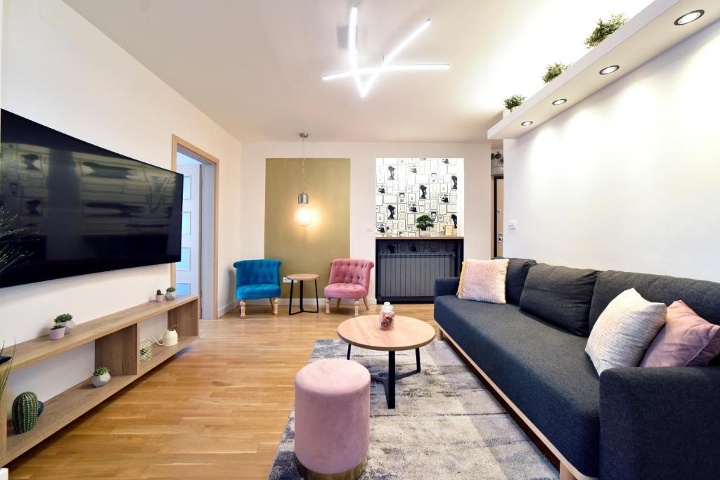 a living room with a couch and a tv at First Choice Ilica - Spacious 3-Bedroom Apartment with Parking in Zagreb